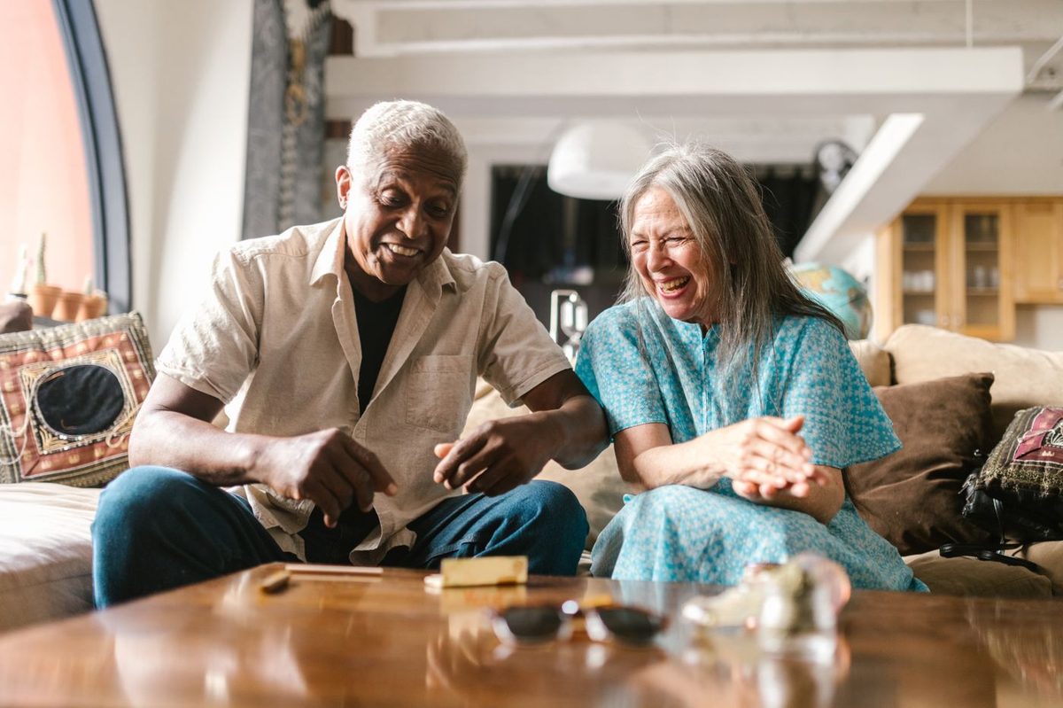 An older couple laughing together outdoors